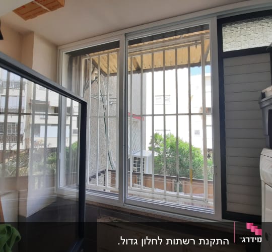 חלון אלומיניום עם סורגים ומסגרת זכוכית פתוחה